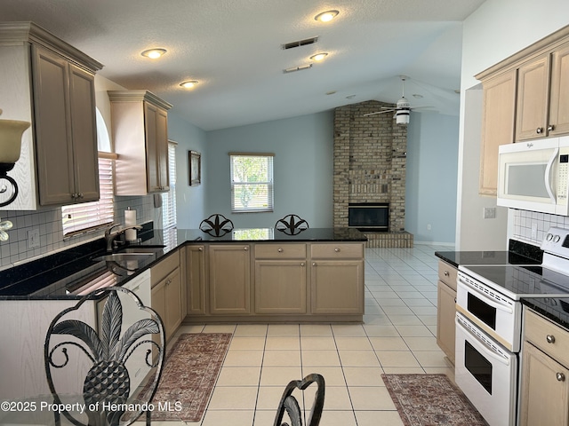 10519 Audie Brook Dr, Spring Hill, FL 34608 - kitchen featuring white appliances, a sink, lofted ceiling, dark countertops, and a peninsula