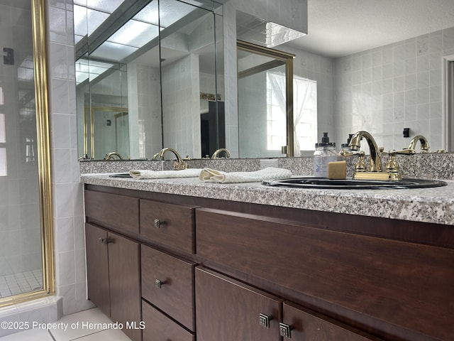 10519 Audie Brook Dr, Spring Hill, FL 34608 - full bathroom featuring a stall shower, tile walls, and double vanity