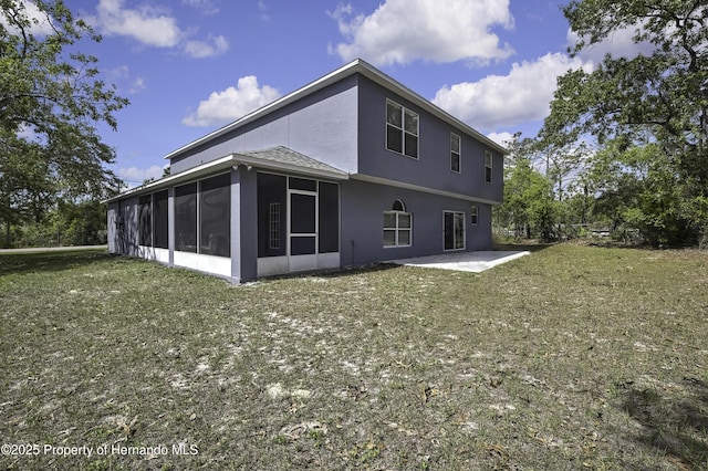 11257 Persimmon Ave, Weeki Wachee, FL 34614 - back of house featuring a lawn, stucco siding, a patio, and a sunroom