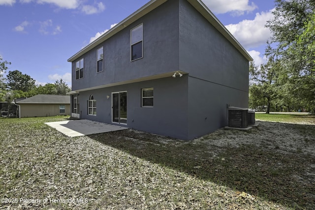 11257 Persimmon Ave, Weeki Wachee, FL 34614 - rear view of house featuring stucco siding, cooling unit, and a patio area