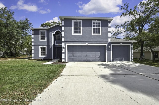 11257 Persimmon Ave, Weeki Wachee, FL 34614 - traditional-style house featuring a garage, a front lawn, concrete driveway, and stucco siding