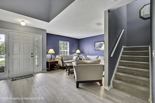 11257 Persimmon Ave, Weeki Wachee, FL 34614 - foyer featuring a textured ceiling, wood finished floors, baseboards, and stairs