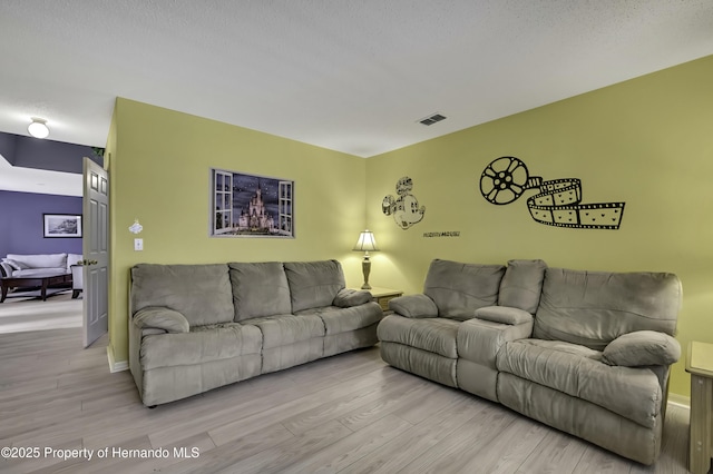 11257 Persimmon Ave, Weeki Wachee, FL 34614 - living area featuring visible vents, wood finished floors, and baseboards