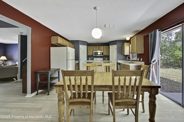 11257 Persimmon Ave, Weeki Wachee, FL 34614 - dining room with a textured ceiling, visible vents, and baseboards