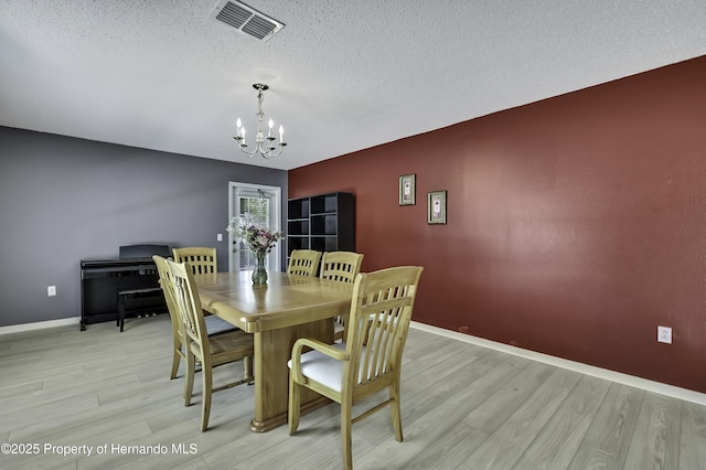 11257 Persimmon Ave, Weeki Wachee, FL 34614 - dining room with an inviting chandelier, baseboards, light wood-style flooring, and visible vents