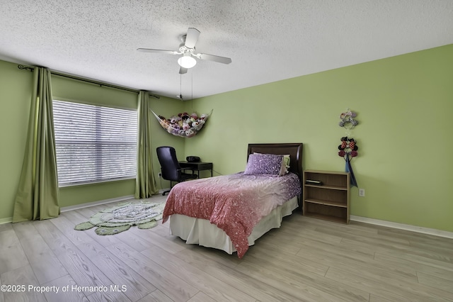 11257 Persimmon Ave, Weeki Wachee, FL 34614 - bedroom featuring baseboards, wood finished floors, and a textured ceiling