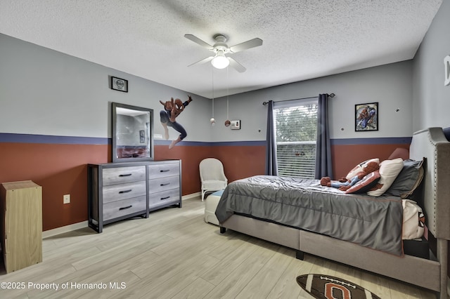 11257 Persimmon Ave, Weeki Wachee, FL 34614 - bedroom featuring baseboards, wood finished floors, a ceiling fan, and a textured ceiling