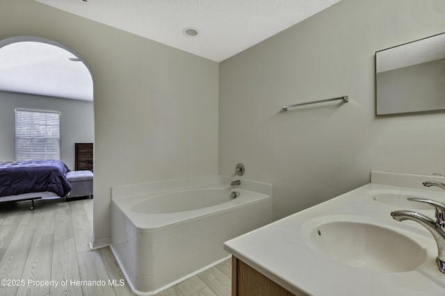 11257 Persimmon Ave, Weeki Wachee, FL 34614 - ensuite bathroom featuring wood finished floors, a bath, and a sink