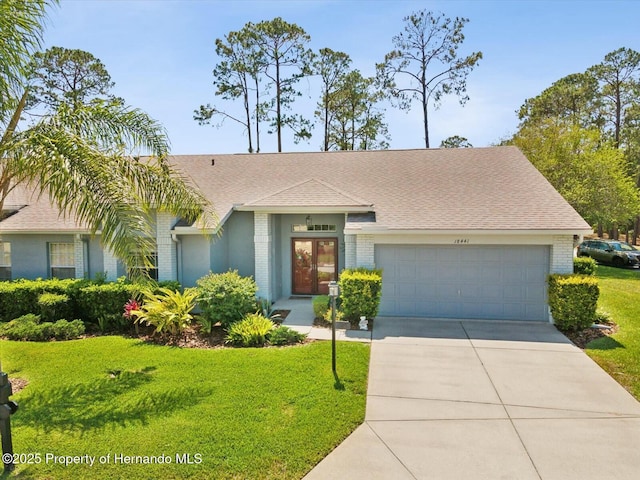 18441 Whitacre Cir, Hudson, FL 34667 - single story home with a front yard, concrete driveway, brick siding, and an attached garage
