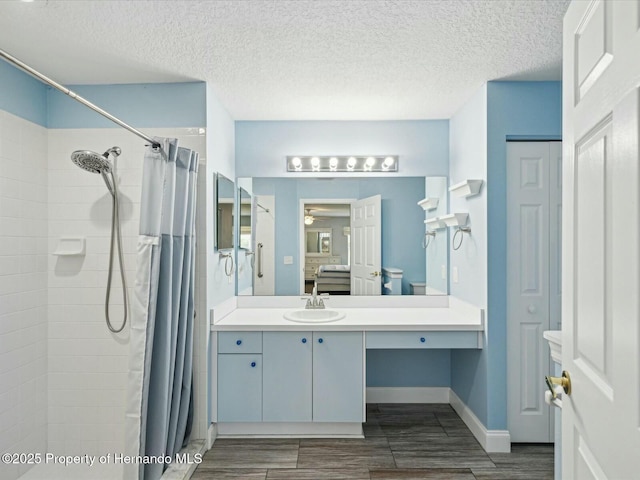 18441 Whitacre Cir, Hudson, FL 34667 - bathroom with wood finished floors, a tile shower, vanity, baseboards, and a ceiling fan