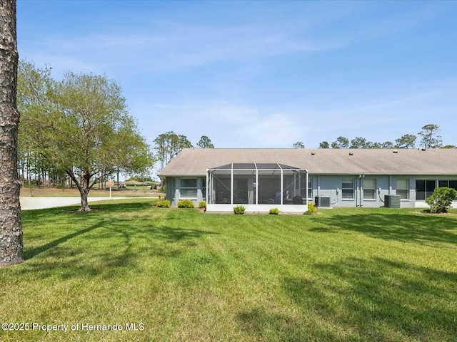 18441 Whitacre Cir, Hudson, FL 34667 - back of house with cooling unit, a yard, and a lanai