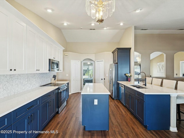 kitchen with a center island, stainless steel appliances, blue cabinets, and a sink