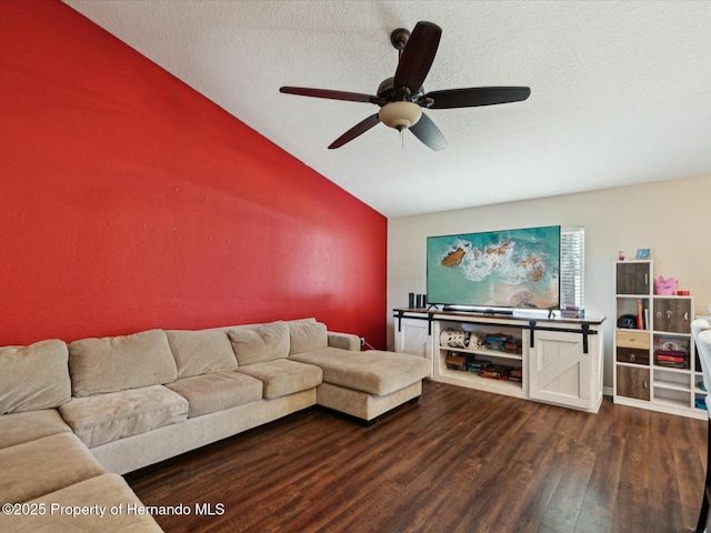 living area with a textured ceiling, dark wood-style flooring, ceiling fan, and lofted ceiling