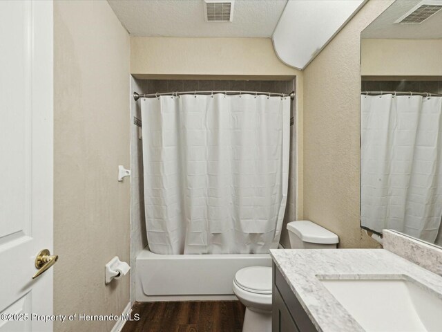 bathroom with toilet, vanity, visible vents, and wood finished floors