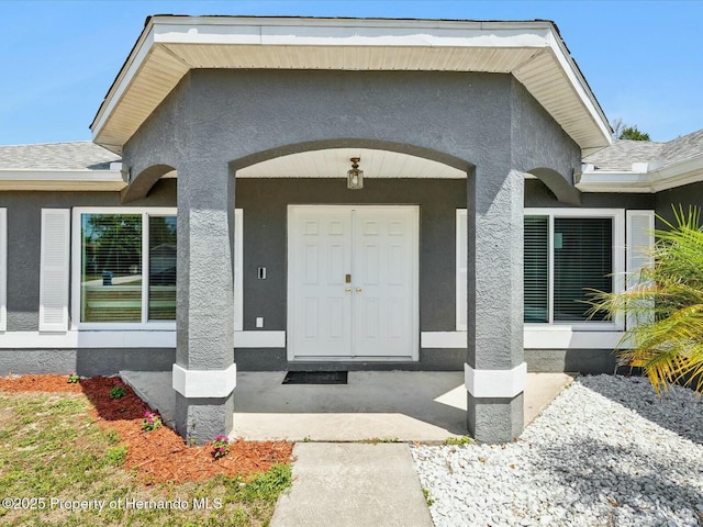 view of exterior entry featuring stucco siding