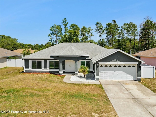 single story home featuring fence, concrete driveway, a front yard, and an attached garage