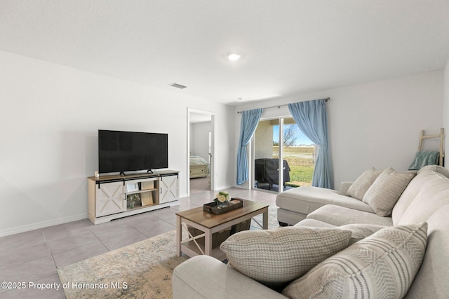 tiled living room with visible vents and baseboards