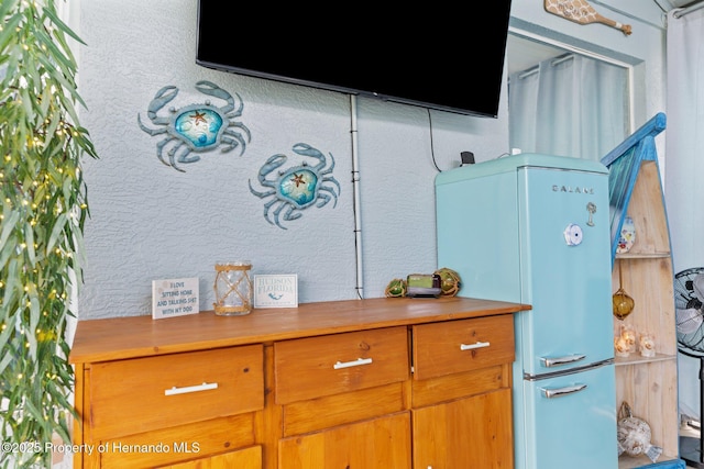 details with freestanding refrigerator and stucco siding