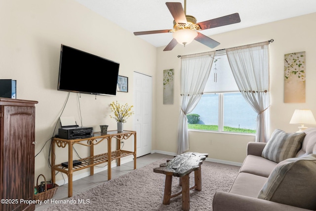 living area with baseboards and ceiling fan