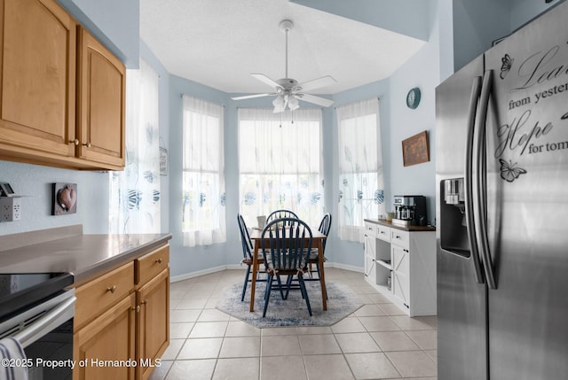 dining room with baseboards, a textured ceiling, ceiling fan, and light tile patterned floors