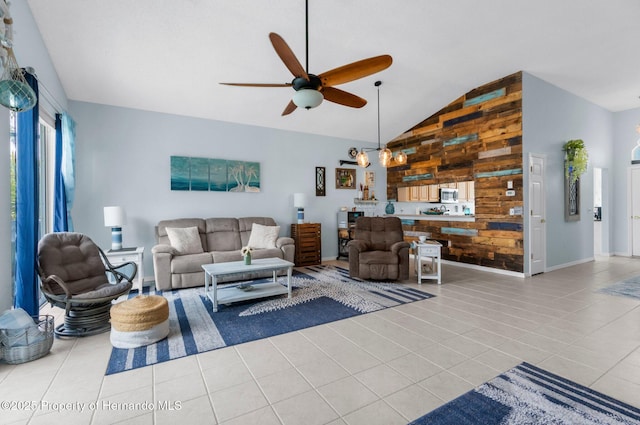 tiled living area with baseboards, a ceiling fan, vaulted ceiling, and wood walls