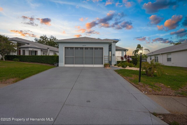 view of front of home with a garage, stucco siding, driveway, and a front yard