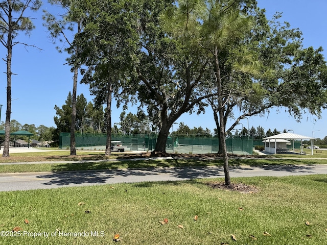 view of community featuring a lawn, fence, and a gazebo