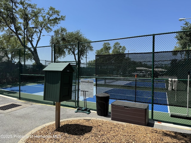 view of sport court with fence and a gate
