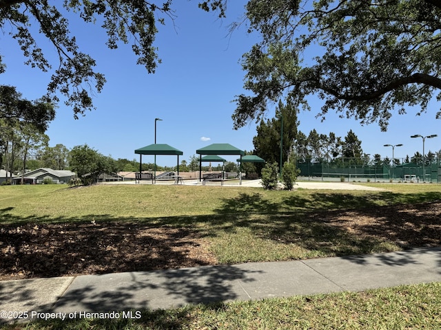 view of home's community with a yard and fence