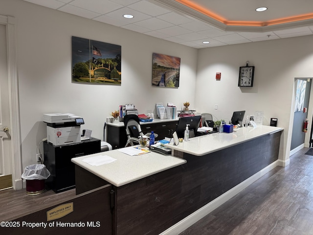 office featuring baseboards, a drop ceiling, recessed lighting, and wood finished floors