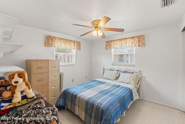 6424 Ponder Dr, Port Richey, FL 34668 - bedroom featuring light speckled floor, ceiling fan, a textured ceiling, and visible vents