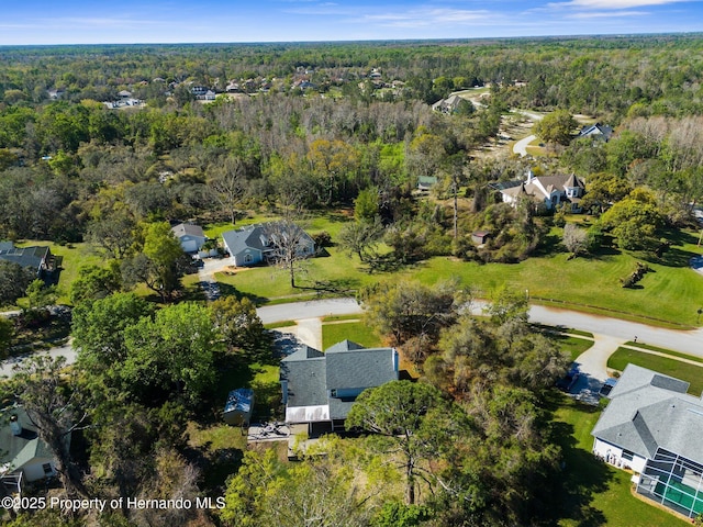 drone / aerial view featuring a residential view and a forest view