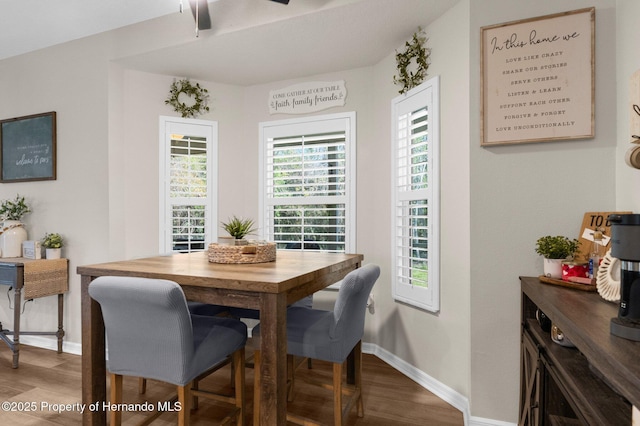 dining area featuring baseboards, ceiling fan, and wood finished floors