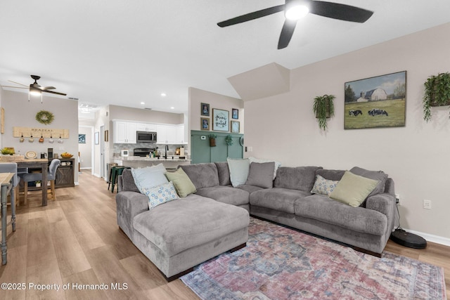 living room with light wood-style floors, recessed lighting, baseboards, and ceiling fan