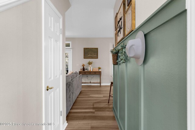 corridor featuring baseboards and wood finished floors
