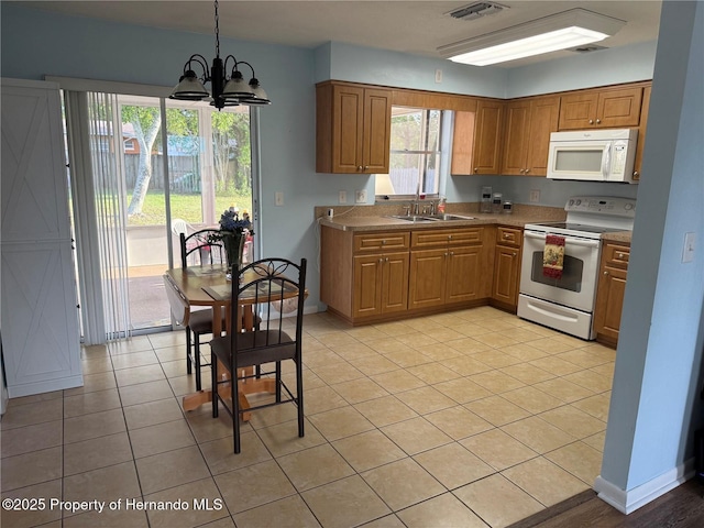 10 Michigan St, Beverly Hills, FL 34465 - kitchen with brown cabinets, an inviting chandelier, a sink, white appliances, and visible vents