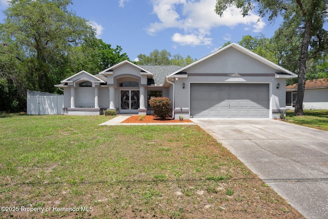 single story home featuring fence, a front lawn, a garage, stucco siding, and driveway