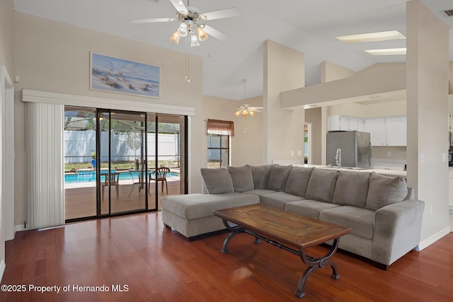 living area featuring high vaulted ceiling, a ceiling fan, wood finished floors, and visible vents