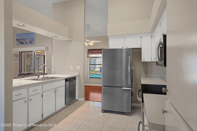 kitchen featuring a sink, light countertops, stainless steel appliances, white cabinetry, and light tile patterned floors