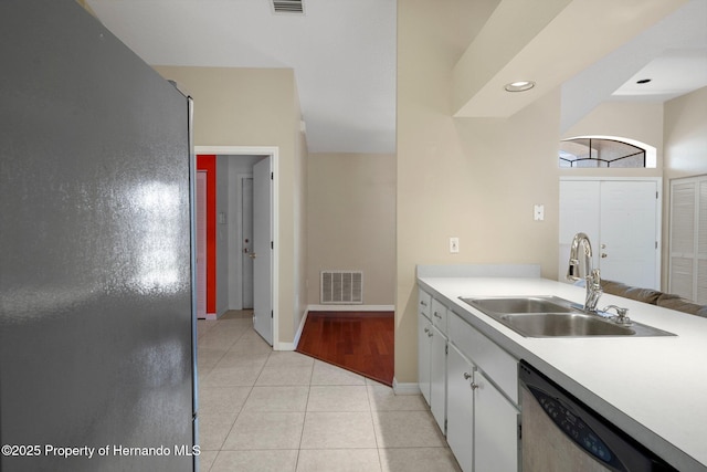 kitchen with a sink, light countertops, baseboards, stainless steel dishwasher, and visible vents