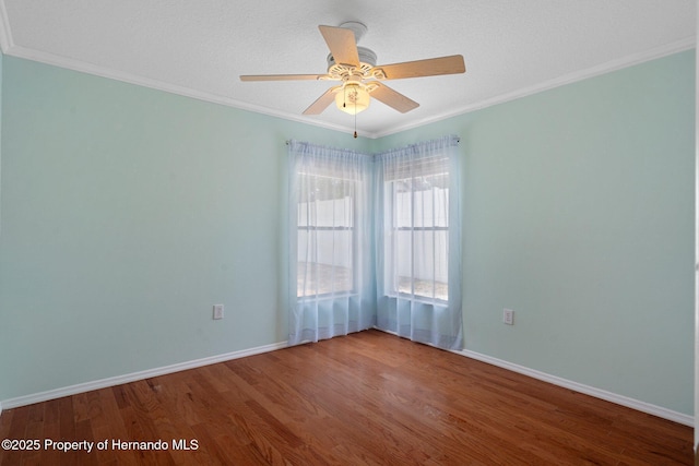 spare room featuring ornamental molding, a ceiling fan, and wood finished floors