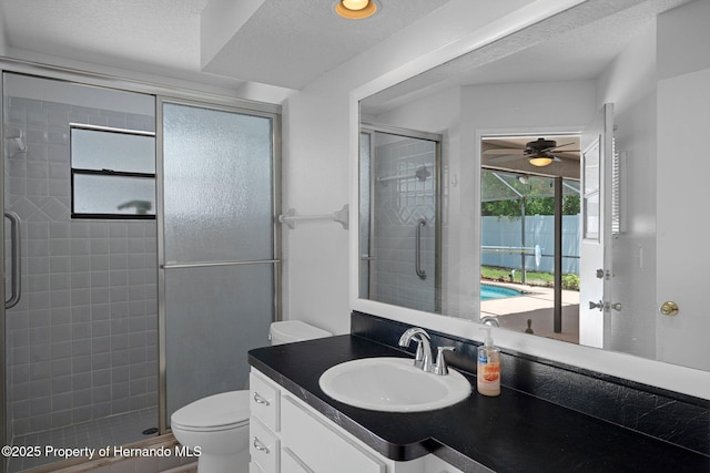 full bathroom with vanity, toilet, ceiling fan, and a stall shower