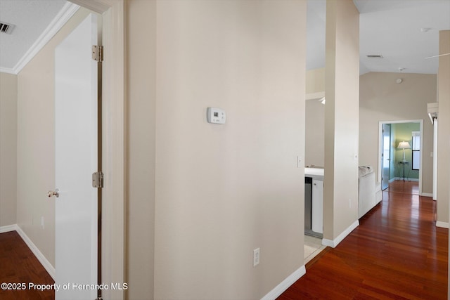 corridor with baseboards, vaulted ceiling, and wood finished floors