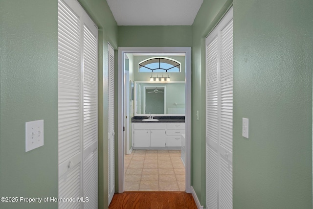 hall with a textured wall and a sink
