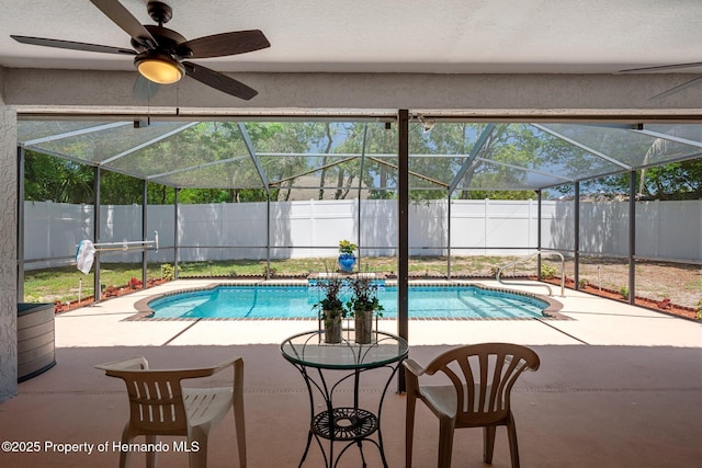 view of swimming pool with a fenced in pool, a fenced backyard, glass enclosure, and a patio area
