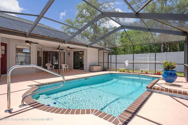 view of pool with a ceiling fan, a patio area, glass enclosure, fence, and a fenced in pool