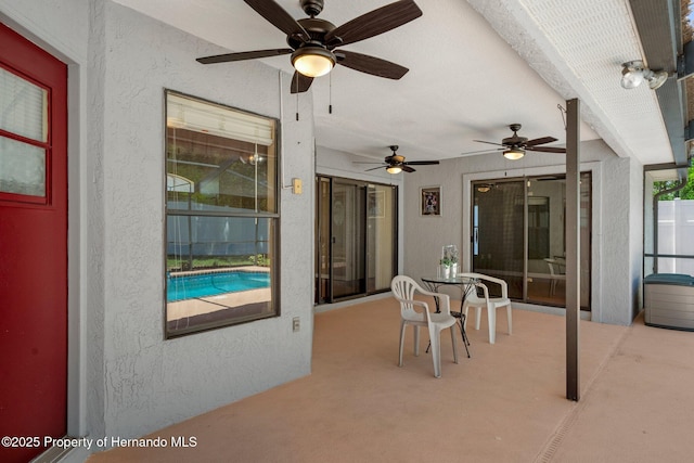 view of patio / terrace with ceiling fan and an outdoor pool
