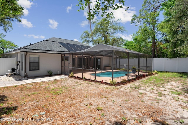 rear view of house featuring a fenced backyard, a fenced in pool, a patio area, and glass enclosure