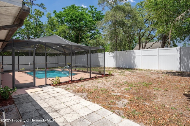 view of swimming pool featuring a fenced backyard, a fenced in pool, a patio area, and a lanai