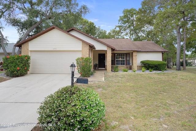 ranch-style home with an attached garage, driveway, a front lawn, and brick siding